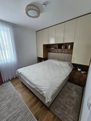 a bedroom with a large bed with white cabinets at Winter Tale in Kopaonik