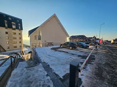 a building with cars parked in a parking lot with snow at Winter Tale in Kopaonik