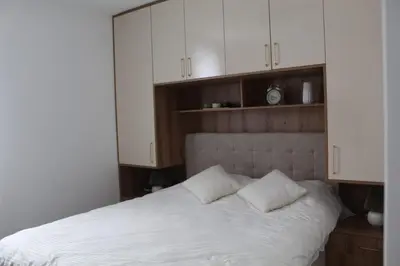 a bedroom with a white bed with white cabinets at Winter Tale in Kopaonik
