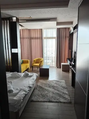 a hotel room with a bed and a living room at Pogled sa oblaka -- View from the clouds in Kopaonik