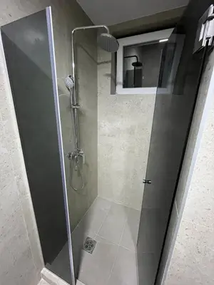 a shower with a glass door in a bathroom at Saška Apartments in Niš