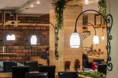 a dining room with a table and chairs and lights at Apartments Sia in Kopaonik