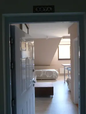 a door to a room with a bed and a table at Apartments Sia in Kopaonik