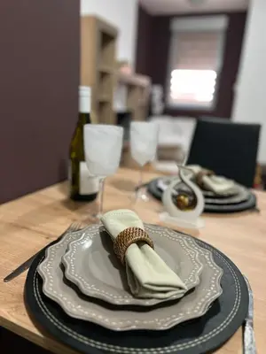 a table with a plate and a bottle of wine at Apartman Irena in Niš