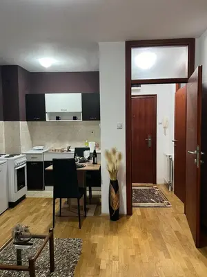 a kitchen and a dining room with a table and a kitchen at Apartman Irena in Niš