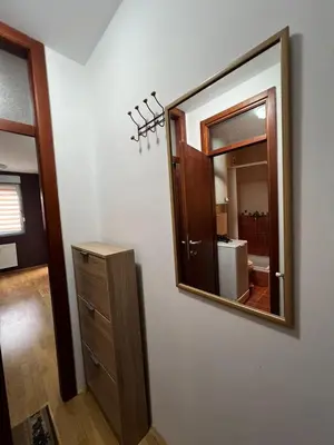 a bathroom with a mirror and a wooden dresser at Apartman Irena in Niš