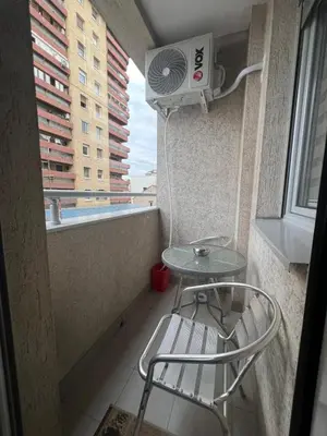 a room with a table and a fan and a chair at Apartman Irena in Niš