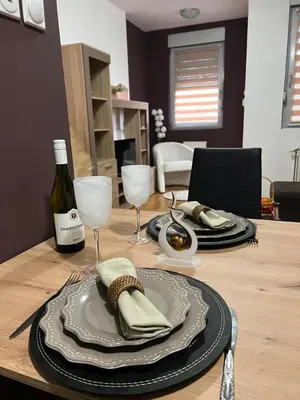 a table with a plate and a bottle of wine at Apartman Irena in Niš
