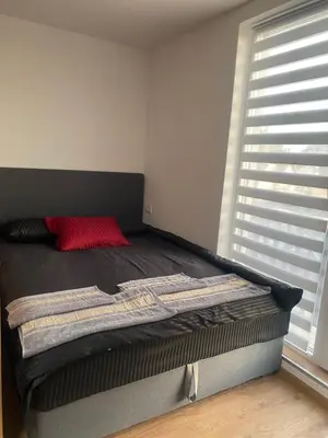 a bed in a room with a red pillow on it at ChiaraKop in Kopaonik