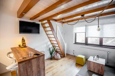 a living room with a staircase and a television at Apartman B24 Vidik Residence in Kopaonik