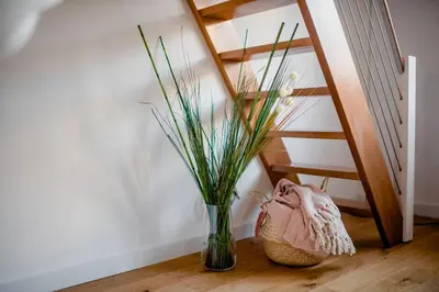 a vase with grass in it next to a staircase at Apartman B24 Vidik Residence in Kopaonik