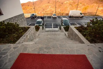 a parking lot with cars and a red carpet at Apartman B24 Vidik Residence in Kopaonik