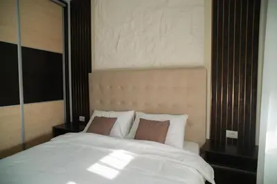 a bedroom with a white bed with two pillows at Nedodjija apartman in Leskovac