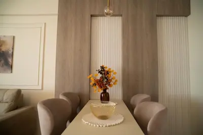 a dining room table with a vase of flowers on it at Nedodjija apartman in Leskovac