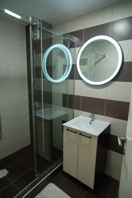 a bathroom with a shower and a sink and a mirror at Nedodjija apartman in Leskovac