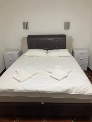 a bed with white sheets and two white pillows at Vila Nina Kopaonik in Kopaonik