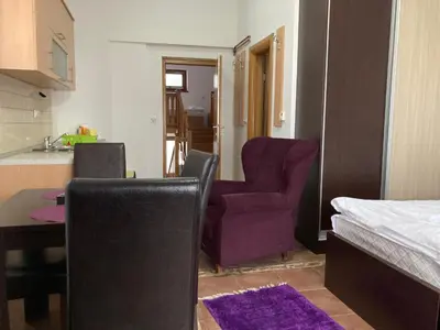 a room with a table and two chairs and a kitchen at Vila Nina Kopaonik in Kopaonik
