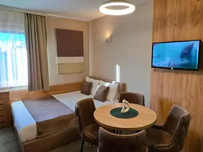 a hotel room with a bed and a table at Celestis Apartmani Konaci in Kopaonik