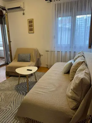 a bedroom with a bed and a table and a window at V&V Apartments in Niš