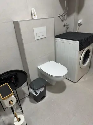 a bathroom with a toilet and a washing machine at V&V Apartments in Niš