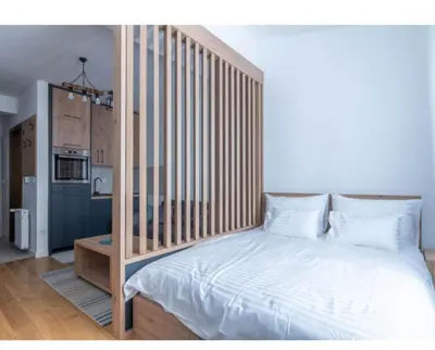 a bedroom with a white bed with a wooden headboard at Apartman Vidik Residence A27 Kopaonik in Kopaonik