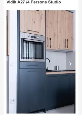 a kitchen with a stainless steel oven and wooden cabinets at Apartman Vidik Residence A27 Kopaonik in Kopaonik