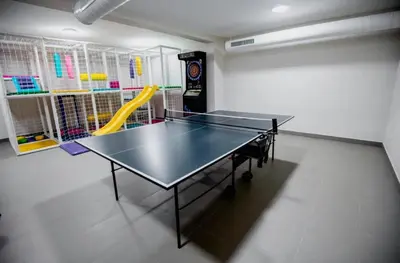 a ping pong table and chairs in a room at Apartman Vidik Residence A27 Kopaonik in Kopaonik