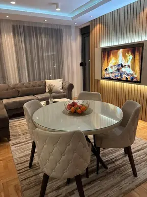 a living room with a table and chairs and a couch at Comfortable Nis Apartment in Niš