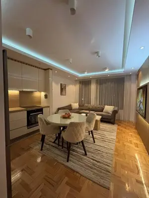 a living room with a table and a couch at Comfortable Nis Apartment in Niš
