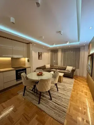 a living room with a table and a couch at Comfortable Nis Apartment in Niš