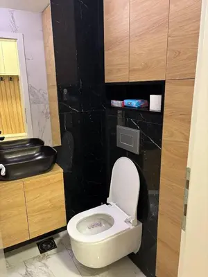 a bathroom with a white toilet and a black wall at Comfortable Nis Apartment in Niš