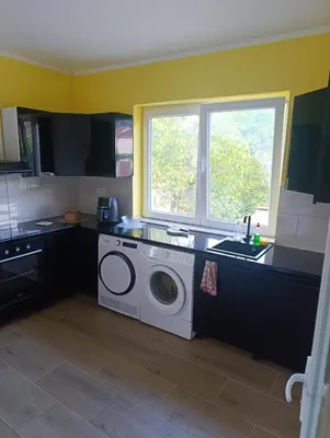 a washing machine in a kitchen with a sink and a window at Tara in Surdulica
