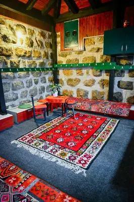 a room with a red table and a stone wall at 369 Vila in Pirot