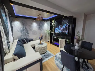 a living room with a white couch and a table at APARTMAN POSEJDON DELUXE- EXCLUSIVe in Vrnjačka Banja