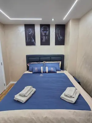a bedroom with a blue bed with towels on it at APARTMAN POSEJDON DELUXE- EXCLUSIVe in Vrnjačka Banja