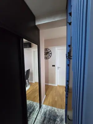 a room with a mirror and a hallway with a chair at APARTMAN POSEJDON DELUXE- EXCLUSIVe in Vrnjačka Banja