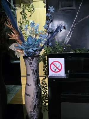 a vase with flowers in it with a no smoking sign at APARTMAN POSEJDON DELUXE- EXCLUSIVe in Vrnjačka Banja