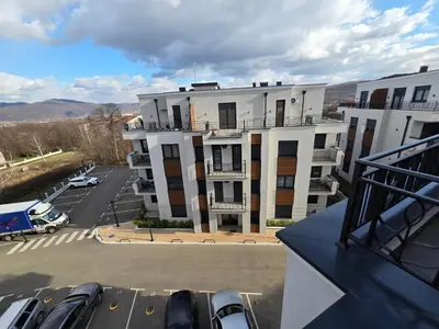 a parking lot with cars parked in front of a building at APARTMAN POSEJDON DELUXE- EXCLUSIVe in Vrnjačka Banja