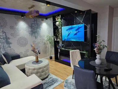 a living room with a white couch and a tv at APARTMAN POSEJDON DELUXE- EXCLUSIVe in Vrnjačka Banja