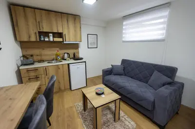a living room with a blue couch and a kitchen at Bakina kuca in Pirot