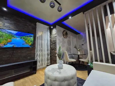 a living room with a tv and a table at POSEJDON DELUXe 4 in Vrnjačka Banja