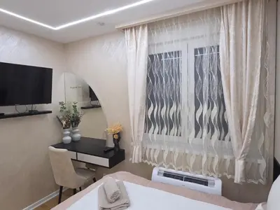 a room with a desk and a window with curtains at POSEJDON DELUXe 4 in Vrnjačka Banja