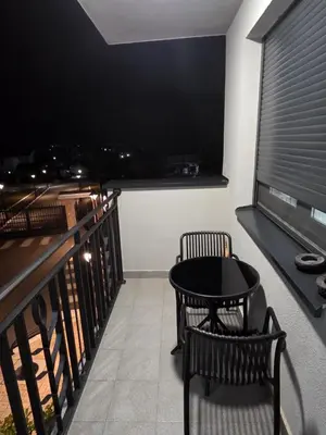 a balcony with a table and a large television at POSEJDON DELUXe 4 in Vrnjačka Banja