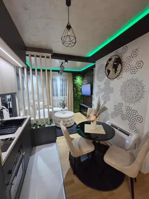 a kitchen with a table and chairs and a living room at POSEJDON DELUXe 4 in Vrnjačka Banja