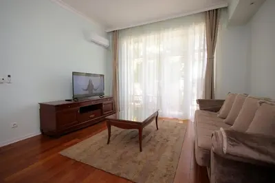 a living room with a couch and a table and a tv at Apartman A4 - Vila Opera in Vrnjačka Banja