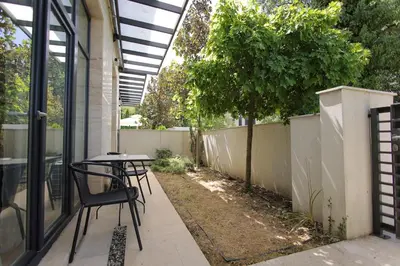 a patio with a table and chairs and a fence at Apartman A4 - Vila Opera in Vrnjačka Banja