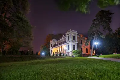 a large white house at night with lights on it at Apartman A4 - Vila Opera in Vrnjačka Banja