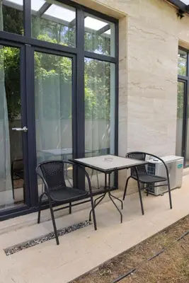 a patio with two chairs and a table on a patio at Apartman A4 - Vila Opera in Vrnjačka Banja