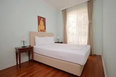 a bedroom with a white bed and a window at Apartman A4 - Vila Opera in Vrnjačka Banja