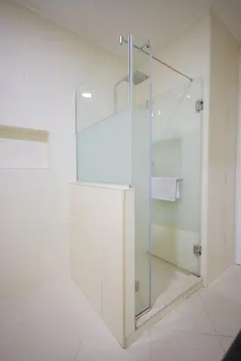 a glass shower in a bathroom with white tiles at Apartman A4 - Vila Opera in Vrnjačka Banja